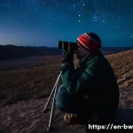 천문 관광을 위한 필수 장비 - **A Serene Night of Binocular Stargazing:** A person, warmly dressed in practical outdoor clothing w...